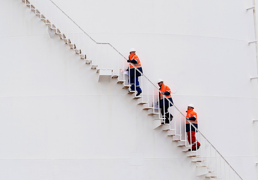 3 men with orange jacket waking up the stairs