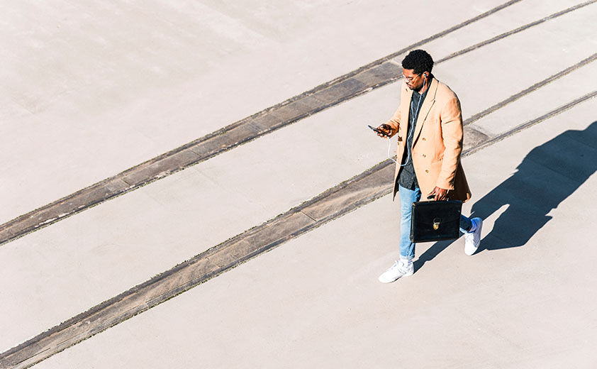 man in camelhair coat looking at phone