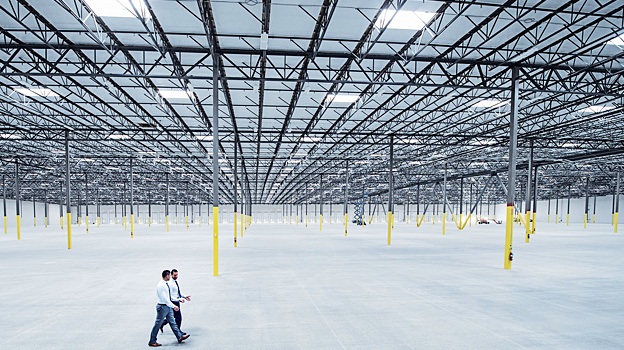 A group of people walking in a large warehouse