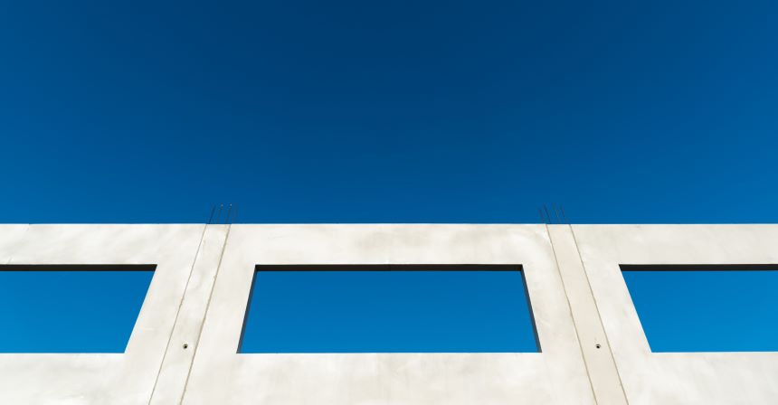 A white wall with windows and blue sky.