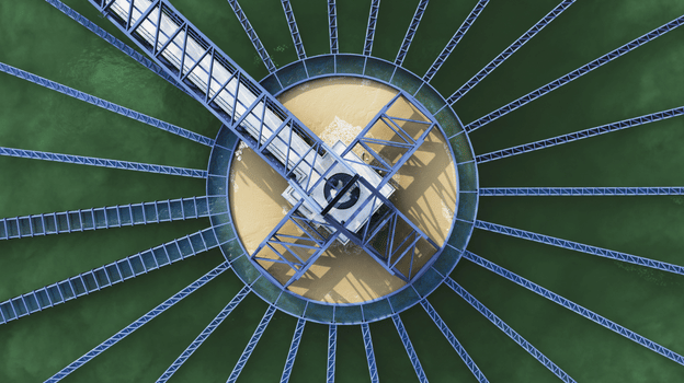 Large circular industrial structure with evenly spaced radial metal beams extending outward from a central hub