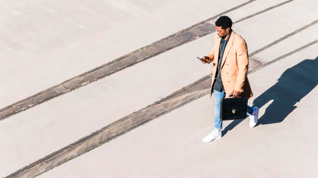 View of a man on his phone, next to some tracks